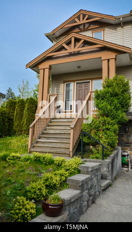 Ingresso principale della casa residenziale con pavimentazione in calcestruzzo e gradini di casa. Foto Stock