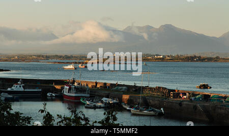 Roundstone in una sera d'estate guardando fuori verso il 12 Bens nel Parco Nazionale del Connemara sulla costa occidentale dell'Irlanda. Foto Stock