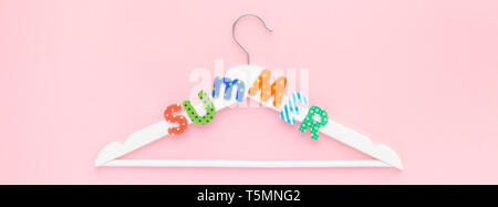 Creative vista superiore piatto bianco laici i portabiti in legno estate testo rosa pastello sfondo spazio copia stile minimalista. Il modello femminile di moda blog sociale Foto Stock