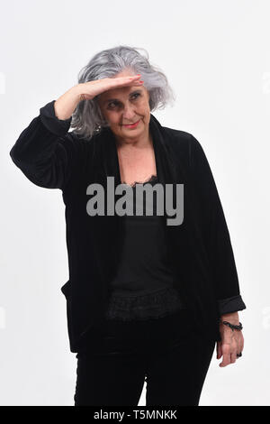 Donna con la mano davanti alla ricerca di distanza su sfondo bianco Foto Stock