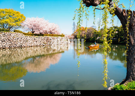 Vecchia barca sul canal con molla Cherry Blossoms presso il castello di Himeji in Giappone Foto Stock