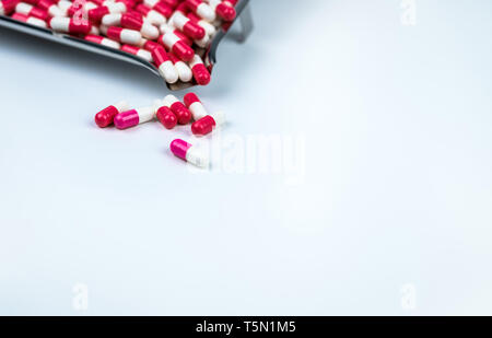 Rosa-bianco e rosso-capsula bianca sul tavolo bianco e sfocata in acciaio inox vassoio di farmaco Amore pillole per il giorno di San Valentino del concetto. Industria farmaceutica Foto Stock