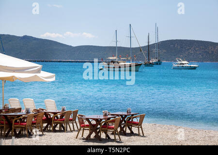 Carino tavolo e sedie e ombrellone in spiaggia al ristorante sul mare a bodrum, Turchia Foto Stock