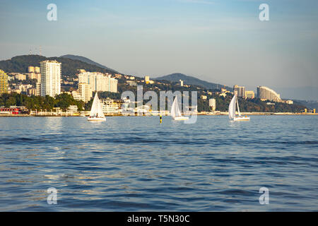 Sochi, Russia-October 8, 2016: regata velica di yacht bianco sullo sfondo della moderna città termale. Foto Stock