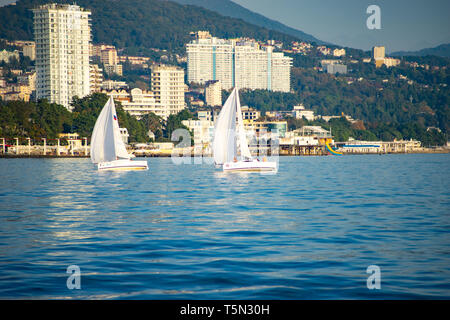 Sochi, Russia-October 8, 2016: regata velica di yacht bianco sullo sfondo della moderna città termale. Foto Stock