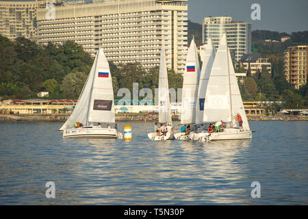 Sochi, Russia-October 8, 2016: regata velica di yacht bianco sullo sfondo della moderna città termale. Foto Stock