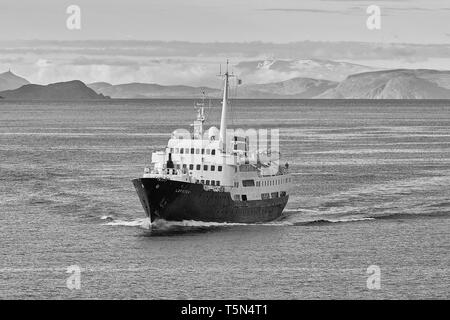 Primo piano in bianco e nero foto della storica nave Hurtigruten, MS Lofoten, fumante in direzione nord, alta sopra il Circolo polare artico norvegese, Norvegia. Foto Stock