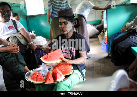 02.09.2013, Yangon, Repubblica dell' Unione di Myanmar, Asia - Una donna è la vendita di fette di cocomero all'interno di un compartimento del treno sulla linea Circle. Foto Stock