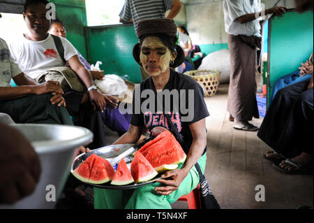 02.09.2013, Yangon, Repubblica dell' Unione di Myanmar, Asia - Una donna è la vendita di fette di cocomero all'interno di un compartimento del treno sulla linea Circle. Foto Stock