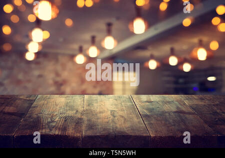 Immagine di un tavolo di legno di fronte astratto ristorante sfocata sullo sfondo delle luci Foto Stock