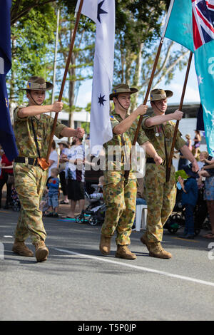 Esercito Australiano si riserva orgogliosamente marciato e bandiere del cuscinetto durante l'Anzac Day street parade Foto Stock