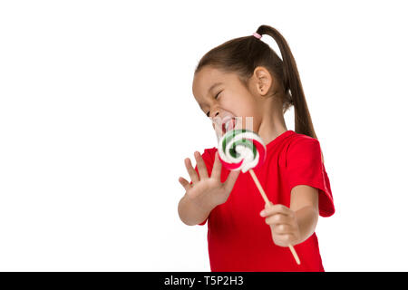 Carino bambina con la caramella lecca-lecca facendo segno di stop isolato su sfondo bianco. Il bambino rifiuta dolce lecca-lecca. No dolci! Foto Stock