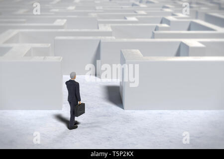 Giocattolo imprenditore in miniatura figurina entrando in un bianco labirinto struttura Foto Stock