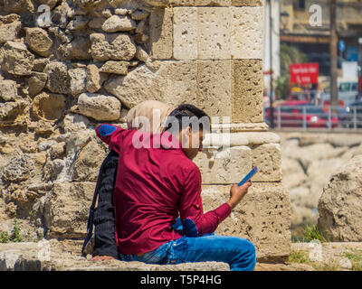 Sidone, Libano - 21 Maggio 2017: Unidentified arabo giovane seduto sulle rovine di Sidone Castello del mare. Foto Stock