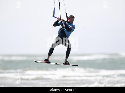 Un kite surfer gode di forti venti sulla West Wittering beach in West Sussex. Storm Hannah è impostato per portare i venti forti e molto le condizioni dello scambiatore di calore per il Regno Unito, con temperature attese di immergersi più di dieci gradi in alcune parti. Foto Stock