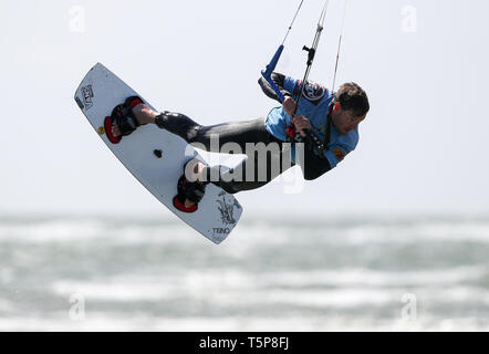 Un kite surfer gode di forti venti sulla West Wittering beach in West Sussex. Storm Hannah è impostato per portare i venti forti e molto le condizioni dello scambiatore di calore per il Regno Unito, con temperature attese di immergersi più di dieci gradi in alcune parti. Foto Stock