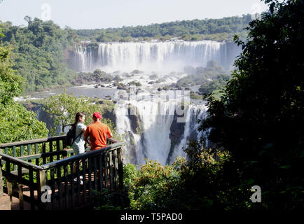 Un turista giovane condividono una vista spettacolare del mighty Iguaçu cade dal lato del Brasile Foto Stock