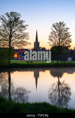 Chiesa di San Lorenzo e di riflessione nel fiume il Tamigi all'alba in primavera. Lechlade sul Tamigi, Cotswolds, Gloucestershire, Inghilterra Foto Stock