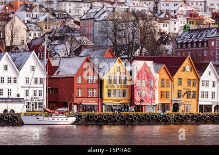 Il tardo inverno a Bryggen e Vaagen, nel porto interno di Bergen, Norvegia. Uno dei buuildings è in fase di ristrutturazione. Foto Stock