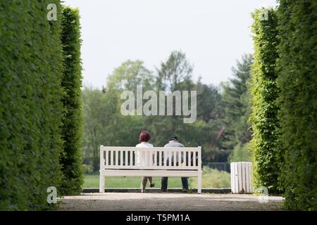 Dresden, Germania. 26 apr, 2019. Due passanti di sedersi su una panchina nel Palazzo di Pillnitz e il parco. Credito: Sebastian Kahnert/dpa-Zentralbild/dpa/Alamy Live News Foto Stock