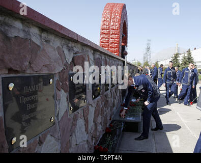 Kiev Kiev, Ucraina. 26 apr, 2019. I lavoratori sono visto la posa di fiori a un monumento di 'liquidatori' durante l anniversario.ucraini ha segnato il 33° anniversario della catastrofe di Chernobyl. L'esplosione del quarto blocco della centrale nucleare di Cernobyl il 26 aprile 1986 è ancora considerato come il più grande incidente nella storia dell energia nucleare. Credito: Pavlo Gonchar SOPA/images/ZUMA filo/Alamy Live News Foto Stock