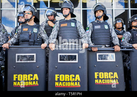 Brasilia, Brasile. 26 apr, 2019. La Força Nacional unità è bloccando l'ingresso al Ministero di Giustizia per ordine del presidente Bolsonaro durante la protesta indigena a Brasilia. Tra le altre cose, gli indigeni protesta per la protezione del loro habitat. Presidente Bolsonaro vuole ridurre la protezione della regione amazzonica e utilizzare la foresta pluviale più economicamente. Credito: Pablo Albarenga/dpa/Alamy Live News Foto Stock