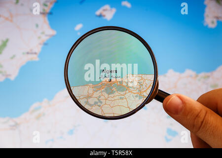 Algeri, Algeria. Mappa politico. Visualizzazione della città concetto illustrativa sullo schermo attraverso la lente di ingrandimento in mano. Foto Stock