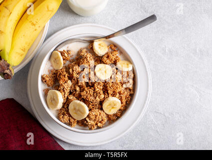 Vista aerea di una ciotola di granola witk fette di banana e latte Foto Stock