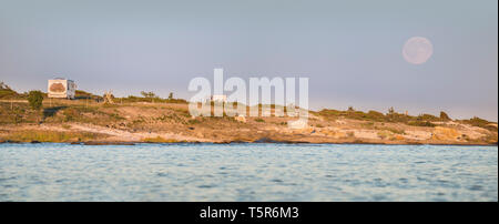 Campeggio in natura, camper parcheggiato su una spiaggia in un bellissimo paesaggio con la luna piena sorge dietro, Gotland, Svezia e Scandinavia Foto Stock