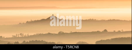 Glastonbury Tor aleggiano sopra un mare di nebbia sui livelli di Somerset durante un brillante tramonto d'autunno. Foto Stock