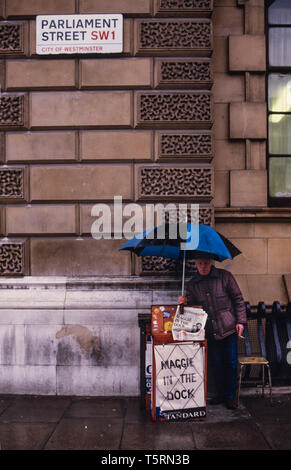 Londra England Regno Unito. Fornitore di giornale in Westminster vicino a Downing Street con il polo negativo a notizia circa il Primo Ministro Margaret Thatcher nel 1985 Foto Stock