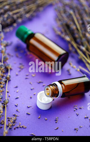 Bottiglie di lavandula olio essenziale, mazzo di essiccato viola i fiori di lavanda. Olio essenziale di lavanda e fiori Foto Stock