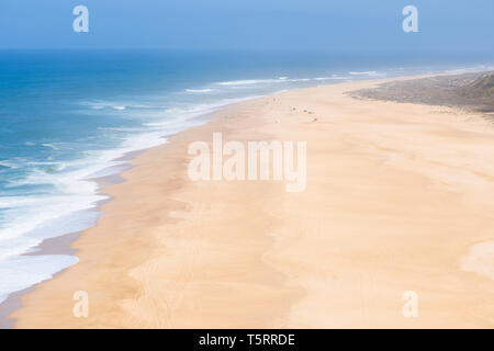 Vista aerea di persone a prendere il sole e giocare su vasta vuoto infinito oceano di sabbia spiaggia a caldo giorno d'estate Foto Stock