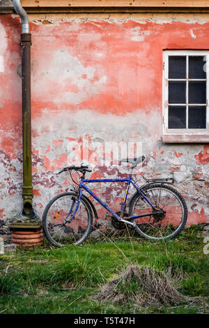 Bicicletta appoggiata contro la parete di sbriciolamento, Copenhagen, Danimarca Foto Stock