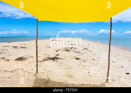 Bellissima spiaggia vista dall'interno della tenda gialla sulla soleggiata giornata estiva. Mare e cielo blu in background. Concetto di vacanze, la pace e il relax.Bahia Foto Stock