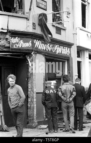 La raccolta di bottiglie da un pub lealisti dopo una bomba dell'IRA in Shankill zona di Belfast, Irlanda del Nord 70s iniziale durante i guai Foto Stock