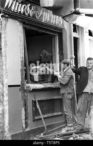 La raccolta di bottiglie da un pub lealisti dopo una bomba dell'IRA in Shankill zona di Belfast, Irlanda del Nord 70s iniziale durante i guai Foto Stock