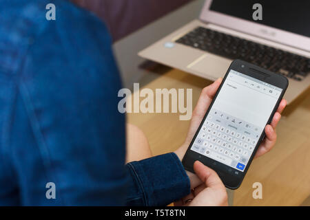 SAN FRANCISCO, USA - 22 Aprile 2019: chiudere fino a mani femminili smartphone tenendo la creazione del piano del progetto da parte di Google Docs applicazione, San Francisco Foto Stock