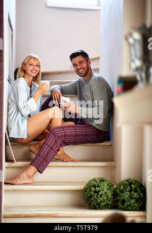Coppia felice di bere il caffè al mattino su scale Foto Stock