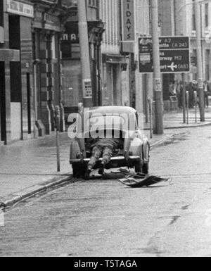 British Army Bomb Disposal soldato Avvio soffiatura della bomba bobby automobile intrappolata in Belfast, agli inizi degli anni settanta, Irlanda del Nord Foto Stock