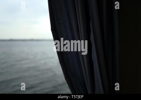 Una tenda nera con il bel mare sullo sfondo Foto Stock