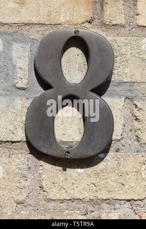 Numero otto su un mattone giallo parete. Foto Stock