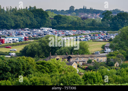 Alta Vista di occupato showground parcheggio auto sotto il cielo azzurro in estate (righe di veicoli parcheggiati in campo) - Grande spettacolo dello Yorkshire, Harrogate, Inghilterra, Regno Unito. Foto Stock