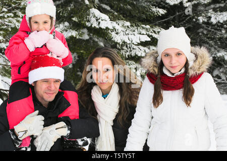 La famiglia felice avendo divertimento sulla neve, Carte di Natale Foto Stock