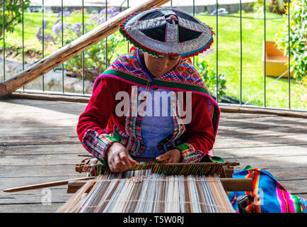 Un Quechua donna indigena che mostra la tecnica di tessitura e la produzione di tessili nella Cordigliera delle Ande del sud America in Cusco, Perù. Foto Stock