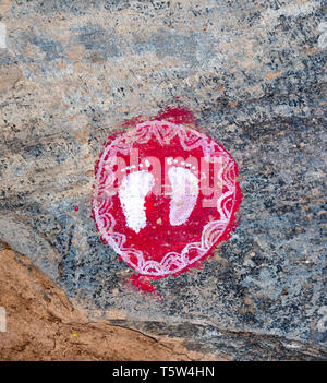 ' Orme della dea Lakshmi ' in bianco su un rosso roundel portando la ricchezza e la buona fortuna per la casa nel villaggio Supi in Uttarakhand Himalaya Foto Stock