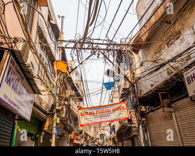 Strade trafficate con energia elettrica caotica e i cavi telefonici nel vecchio quartiere di Delhi in India del Nord Foto Stock