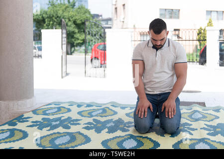 Uomo musulmano rendendo tradizionale preghiera a Dio Allah nella moschea Foto Stock