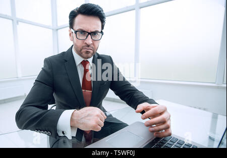 Close up.grave imprenditore conti di controllo mentre è seduto alla sua scrivania.la concezione di business Foto Stock