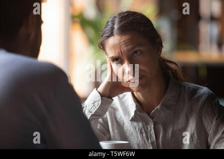 Annoiato donna seduta su speed dating con maschio di trivellazione Foto Stock